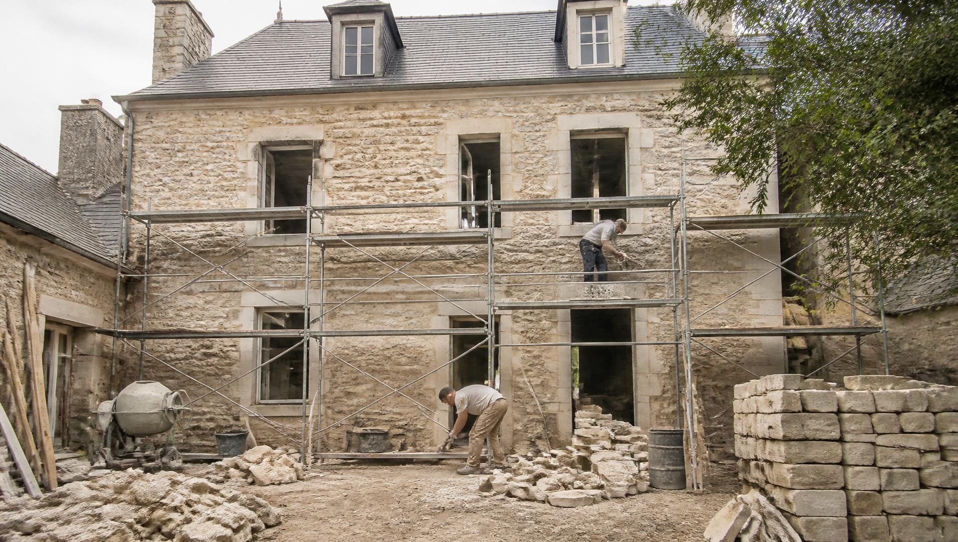 Rénovation lourde d'une maison ancienne en pierre avec échafaudage